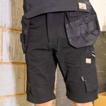 Black tactical shorts with multiple pockets and straps on a neutral background